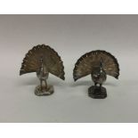 A pair of heavy cast silver peacocks on square bas