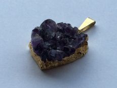 A gold and amethyst mounted pendant of textured fo