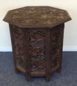 An octagonal carved table decorated with flowers an