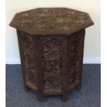 An octagonal carved table decorated with flowers an