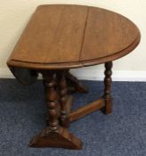 A small oak drop leaf occasional table on turned s