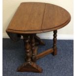 A small oak drop leaf occasional table on turned s