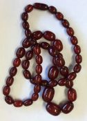 A long string of red amber beads. Approx. 123 gram