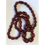 A long string of red amber beads. Approx. 123 gram