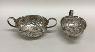 An unusual embossed silver cream jug together with