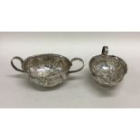 An unusual embossed silver cream jug together with