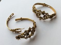 A pair of gold hinged bangles in high carat inset