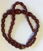 A graduated string of amber type beads with barrel