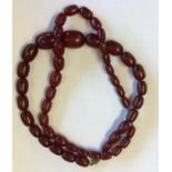 A graduated string of amber type beads with barrel