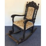A large oak carved rocking chair with upholstered
