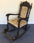 A large oak carved rocking chair with upholstered