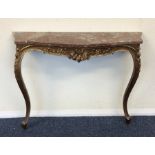 A gilt marble top console table decorated with scr