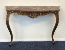 A gilt marble top console table decorated with scr