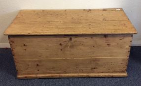 A large pine hinged top trunk. Est. £20 - £30.