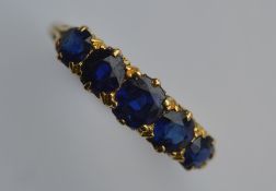 A large sapphire five stone half hoop ring in carv