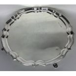 A circular silver salver with wavy edge on cabriol