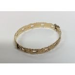 A 9 carat bangle with scroll decoration and concea
