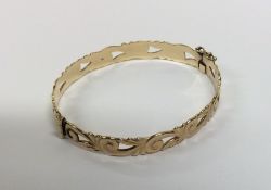 A 9 carat bangle with scroll decoration and concea