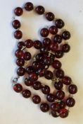A string of red amber beads with gold clasp. Appro