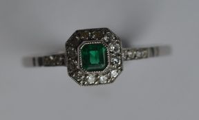 A stylish emerald and diamond cluster ring with cu