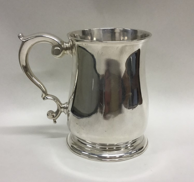 A Georgian silver pint mug with scroll handle. Lon