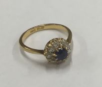 A circular sapphire and diamond cluster ring in 18