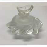 A Lalique glass scent bottle contained within a fi