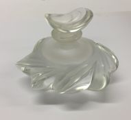 A Lalique glass scent bottle contained within a fi