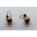 A pair of gold drop earrings in the form of balls