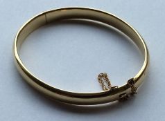 A good high carat gold oval bangle with concealed