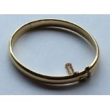 A good high carat gold oval bangle with concealed