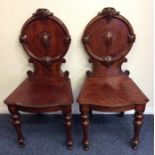 A pair of oak hall chairs on turned supports. Est.