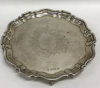 An Edwardian silver waiter decorated with foliage.