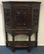 A large oak carved hall cupboard with shaped front