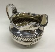 A Georgian circular cream jug with silver gadroon