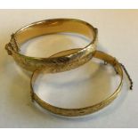 Two gilt and engraved bangles. Est. £10 - £15.