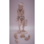 A carved ivory figure of a gent on rocky base. Est