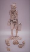 A carved ivory figure of a gent on rocky base. Est