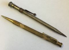 A gold extending pencil together with one other. A