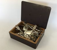A box containing silver plated sugar tongs, grape