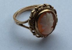 An oval 9 carat cameo ring with rope twist decorat
