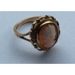 An oval 9 carat cameo ring with rope twist decorat