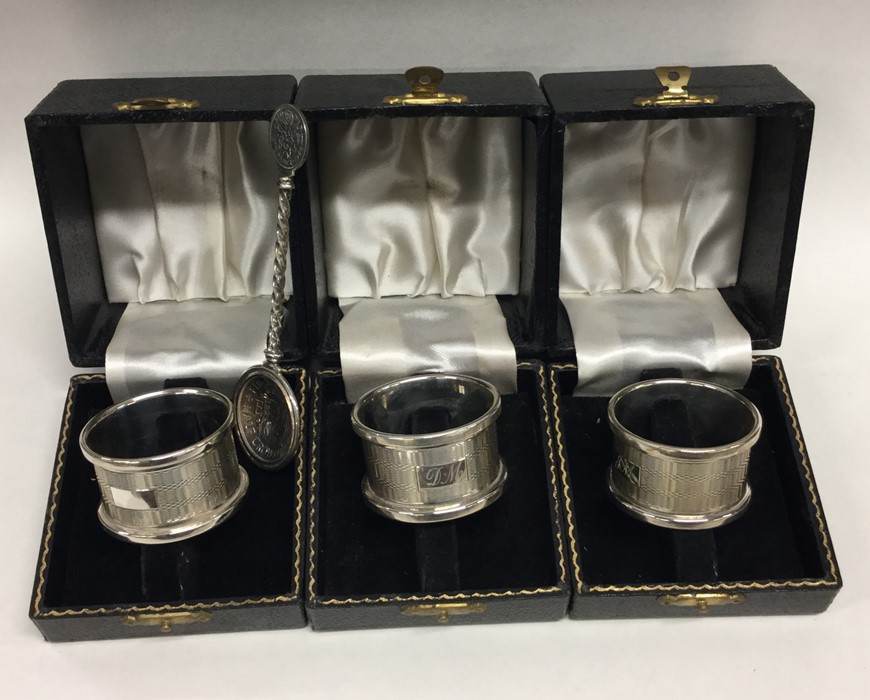 A boxed set of three silver napkin rings together