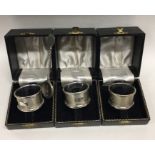 A boxed set of three silver napkin rings together