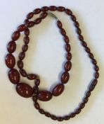 Two graduated strings of red amber beads. Approx.