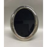 A large oval silver picture frame with rope twist