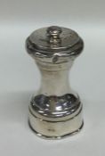 A heavy silver pepper grinder with screw-on cover.