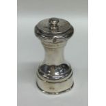 A heavy silver pepper grinder with screw-on cover.