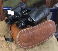 A pair of leather cased binoculars.