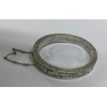 An unusual silver hinged bracelet decorated with f